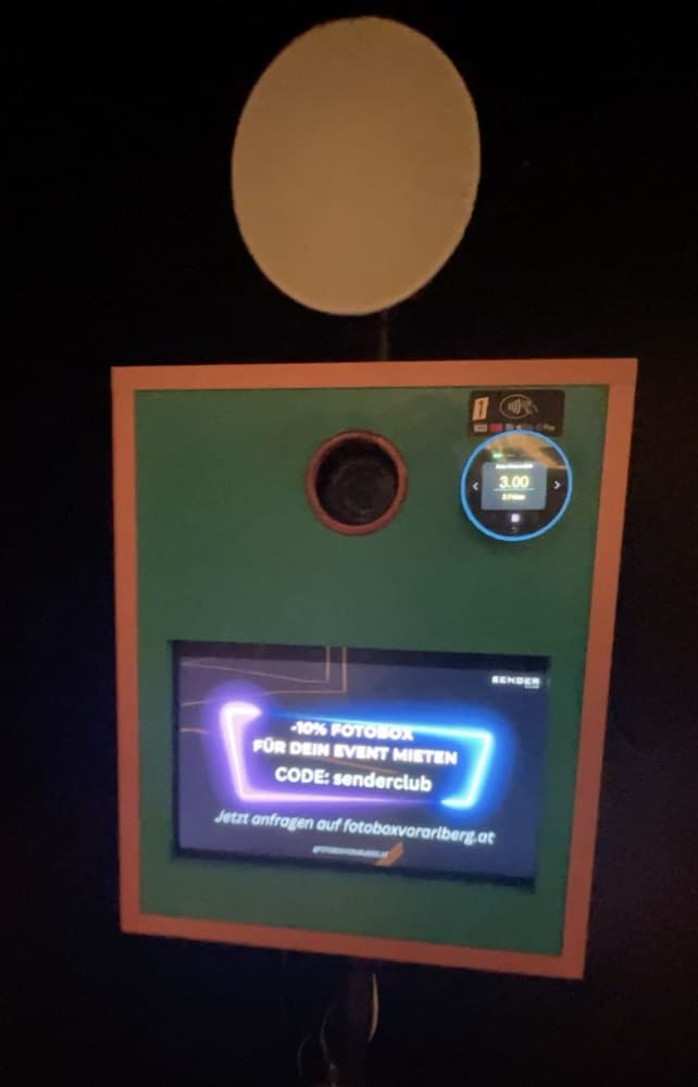 PhotoBooth an der Wand eines Clubs, mit Touchdisplay und kontaktlosem Bezahlterminal